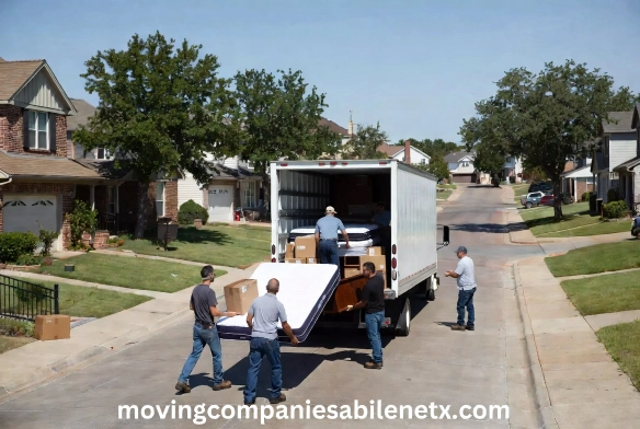 Professional movers loading a mattress into a truck.